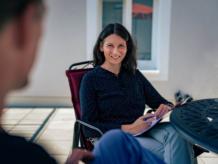 zwei Personen führen ein Therapiegespraech 